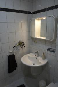 a white bathroom with a sink and a mirror at Fewo Oechler in Seelbach