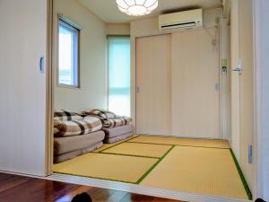 a living room with a sliding door with a couch at Duplex Makishi in Makishimachi