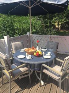 a blue table with a bowl of fruit and an umbrella at Ferienwohnung ALEXA in Walshausen
