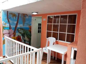 een balkon met een tafel en stoelen en een muurschildering bij Posada J&J Forbes - 2 in San Andrés