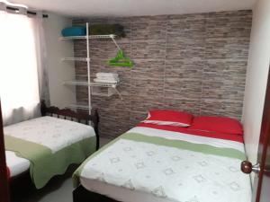 een slaapkamer met 2 bedden en een bakstenen muur bij Posada J&J Forbes - 2 in San Andrés