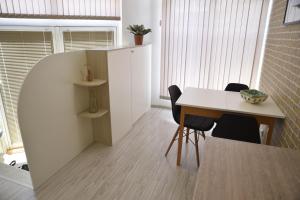 une salle à manger avec une table et des chaises blanches dans l'établissement Studio Toni, à Sliven