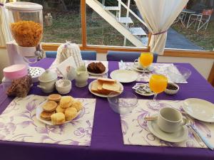 a purple table with food and glasses of orange juice at Hostería Plas y Coed Gwesty in Gaiman