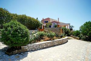 uma casa com uma parede de pedra e um jardim em Villa Myrto em Kyparissia