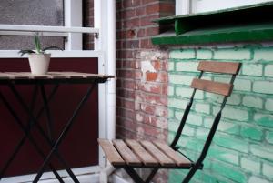 una sedia in legno seduta accanto a un muro di mattoni di new design apartment a Duisburg
