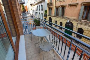 a balcony with a table and chairs on a city street at 3 Amici Suites in Verona