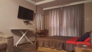 a bedroom with a bed and a flat screen tv at Mimino Apartment Deluxe First Line (C II) in Batumi