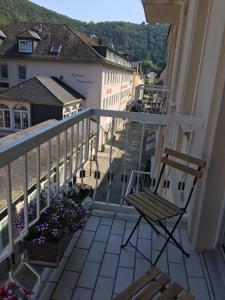 a balcony with a chair and flowers on a building at Vintagehotel Twenty-eight in Bad Bertrich