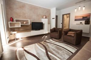 a living room with a couch and a television at Il Golfo Apartment in Lenno