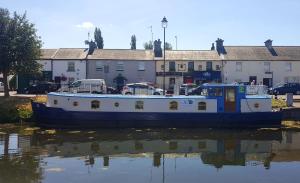 un barco sentado en el agua frente a los edificios en Roisin Dubh Houseboat, en Sallins