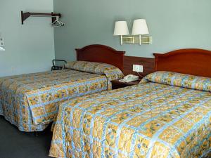 ウィローズにあるEconomy Innのベッド2台、電話が備わるホテルルームです。