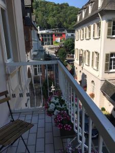 a balcony with a bench and flowers on a building at Vintagehotel Twenty-eight in Bad Bertrich