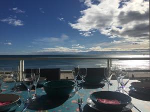 a table with wine glasses and a view of the ocean at Meuble de tourisme classé, climatisation, pieds dans l'eau in Palavas-les-Flots