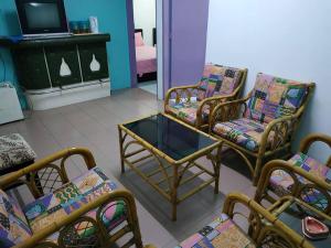 salon z krzesłami, stołem i telewizorem w obiekcie Formosa Hotel Apartment w Malakce