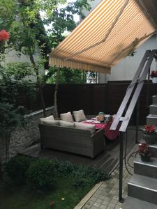 a couch sitting under a pergola on a patio at Cozy apartment city center in Sarajevo