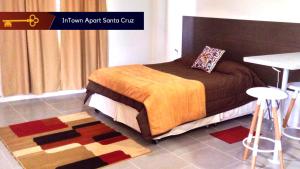 a bedroom with a bed and a table and a rug at InTown Apart Santa Cruz in Santa Cruz