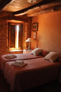 1 dormitorio con 2 camas y ventana en Casa Rural Las Águedas, en Murias de Rechivaldo
