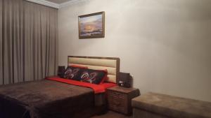 a bedroom with a bed with a red blanket at Mimino Apartment Deluxe First Line (C I) in Batumi