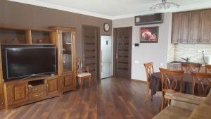 a living room with a television and a dining room at Mimino Apartment Deluxe First Line (C I) in Batumi