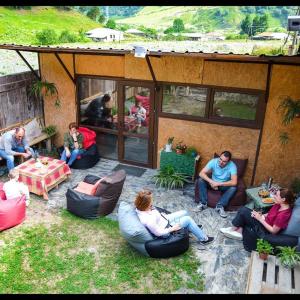 un gruppo di persone seduti su sedie in un cortile di Snoveli Kazbegi a Sno