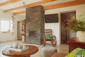 a living room with a stone fireplace and a table at Domek na Zwierzynieckim Rogu in Trygort