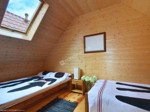 サルビノボにあるBursztynowe Domkiのログキャビン内のベッド2台が備わる部屋です。