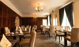 a restaurant with wooden walls and tables and chairs at The Bridge Helmsdale in Helmsdale