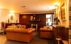 a living room with leather couches and a fireplace at The Bridge Helmsdale in Helmsdale