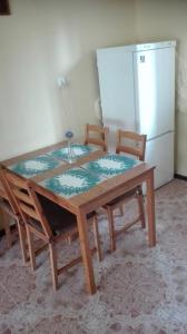 mesa de madera con 2 sillas y nevera en Kwatery Noclegi pracownicze en Wilkasy