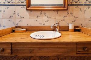 La salle de bains est pourvue d'un comptoir en bois et d'un lavabo. dans l'établissement Casa rural-Granja (La casa de la abuela Juana), à Conil de la Frontera