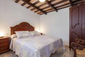 a bedroom with a bed with a white comforter at Casa rural-Granja (La casa de la abuela Juana) in Conil de la Frontera