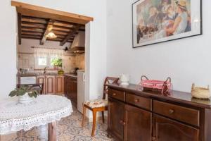 uma cozinha com um balcão e uma mesa num quarto em Casa rural-Granja (La casa de la abuela Juana) em Conil de la Frontera