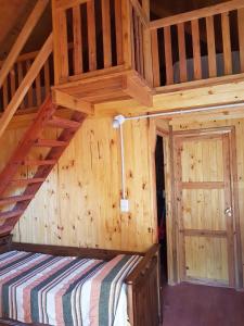 Habitación grande de madera con 1 cama en una cabaña en Los Teros en Goya