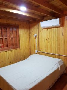 a bed in a wooden room with a window at Los Teros in Goya