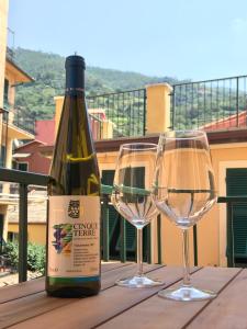 una bottiglia di vino e due bicchieri di vino su un tavolo di Casa Alba a Monterosso al Mare