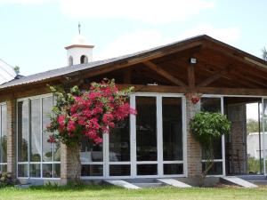 a house with glass doors and pink flowers at Los Teros in Goya