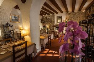 un restaurante con mesas y flores púrpuras en un jarrón en Hostellerie Du Grand Duc, en Gincla