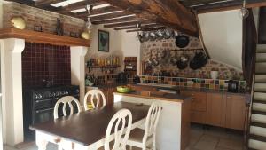 a kitchen with a table and chairs and a stove at Le Moulin du Cluzeau in Chaillac