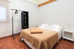 Un dormitorio con una cama con una manta marrón. en Cal Cinque, en La Seu d'Urgell