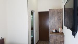 a room with a television and a door to a bathroom at Sweet Rooms Inn in Tbilisi City
