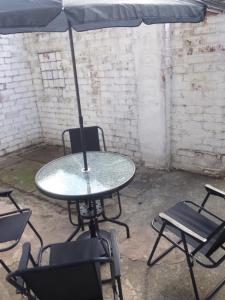 uma mesa e cadeiras com um guarda-sol num quarto em Carfax House em Manchester