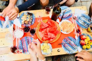 a group of people sitting around a table with food and wine at Bude Hostel in Tbilisi City