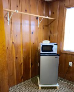 a kitchen with a microwave on top of a refrigerator at Horse Cave Motel in Horse Cave