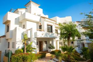 a white building with trees in front of it at Golf Beach and Relax Townhouse in La Alcaidesa
