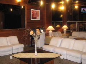 una sala de estar con sofás blancos y una mesa con flores. en Hotel Continental en Montevideo