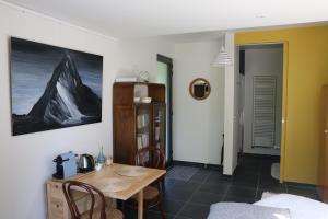 une salle à manger avec une table et un mur jaune dans l'établissement La Chambre d'Amis, à Ypres