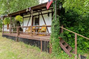 a house with a porch with an american flag at Windmill vacation home in Ledzin near Baltic Sea in Niechorze