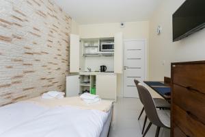 Habitación con cama, escritorio y microondas. en Apartamenty Dom Saski 10 minut od Centrum Warszawy en Varsovia