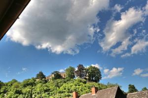 einen blauen Himmel mit Wolken über einem Hügel mit Häusern in der Unterkunft Ferienwohnung Eulenhof in Neustadt an der Weinstraße