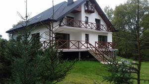 Casa blanca grande con balcón y árboles en Happiness Country Retreat, en Bubel